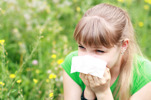 Woman blows her nose outside in the spring